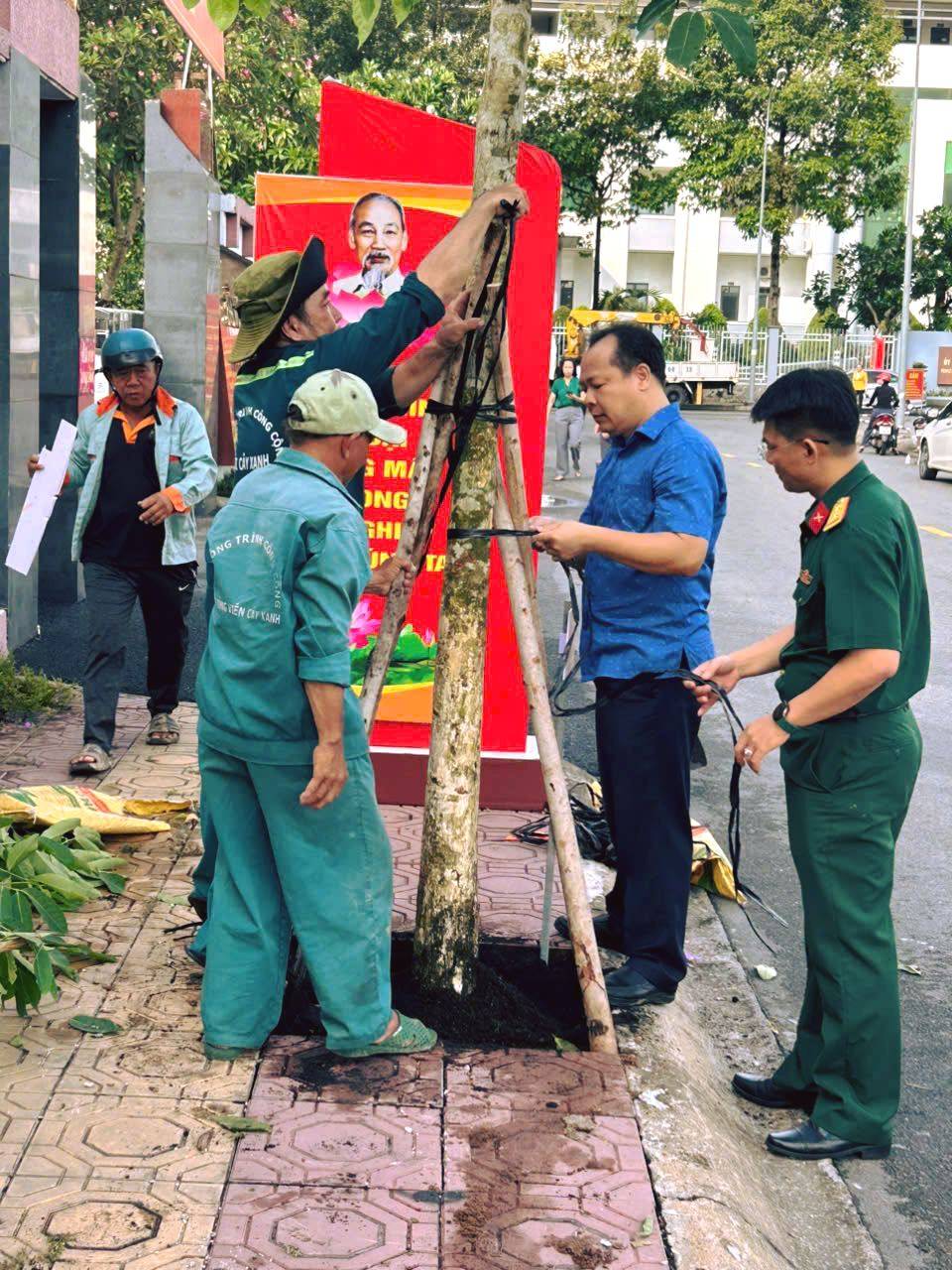 Có thể là hình ảnh về một hoặc nhiều người, cây và văn bản