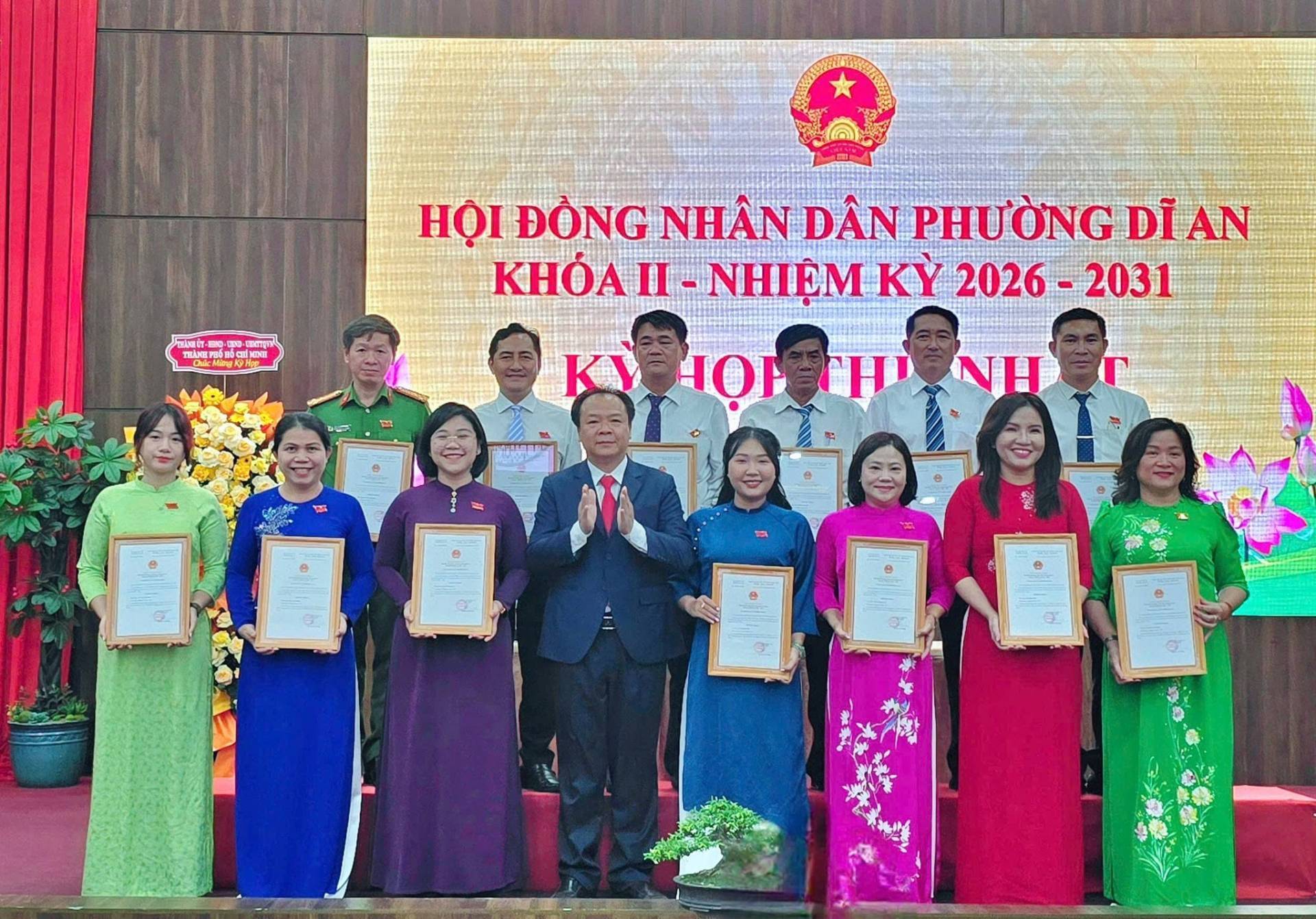 Có thể là hình ảnh về một hoặc nhiều người và văn bản cho biết '正 መ፡ 전을 0税 រុ 加A 网 HỘI ĐỒNG NHÂN DÂN PHƯỜNG DĨ AN ΚHΌΑn-ΝΗEΜΚy ΚΗΌA II -NHIỆM KY 2026 2026-2031 2031 K TMIBNG JOP ΣΗΙ'