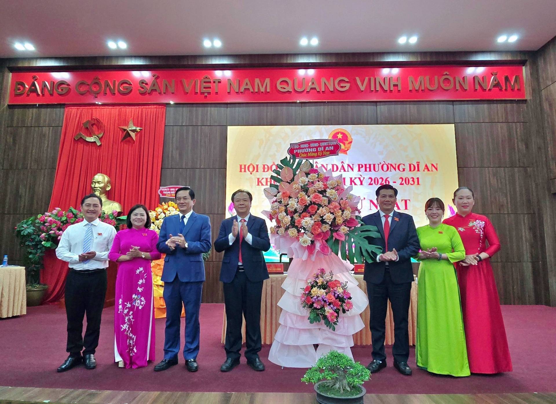 Có thể là hình ảnh về một hoặc nhiều người và văn bản cho biết 'ĐÁNG CỘNG SẮN VIỆT NAM QUANG VINH MUÔN MUÔNNĂM NĂM HỌI HOIĐO ĐỘI KH 斤-11-313 AmLAN PRUERNKA AN NDÂN DAN PHƯỜNG Dİ AN KỲ KY2026-2031 2026 2031 T ge MOS'